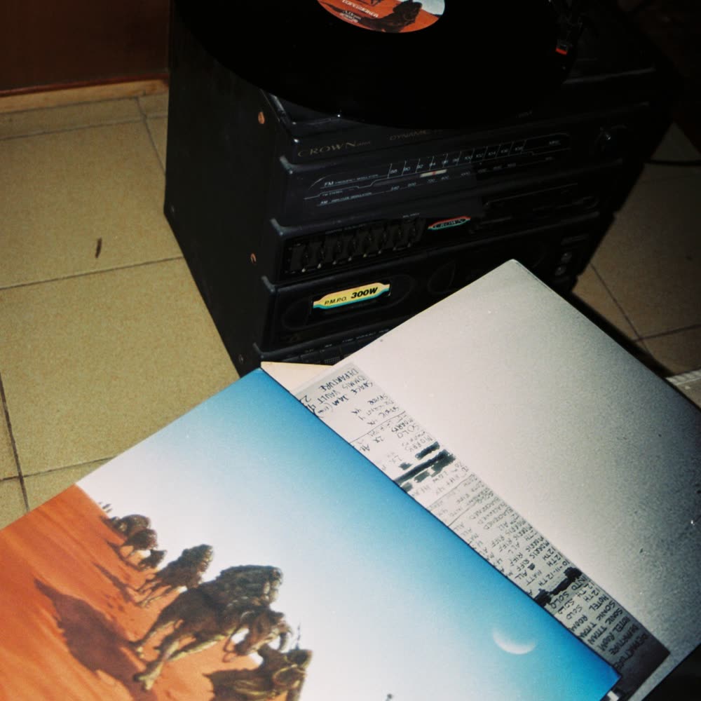 A record on the turntable and its sleeve on the floor